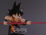 “Vista lateral de Goku niño sosteniendo bastón y mochila con cola de mono”