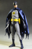 "Figura de acción Batman con accesorios incluidos: batarang, capa de tela y cinturón utilitario detallado."
