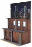 “Vista lateral del diorama NECA con fondo nocturno de ciudad.”